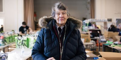 An elderly woman at a food distribution location.