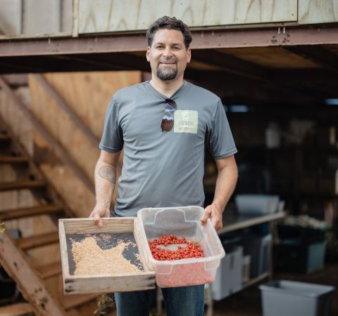 Raul holding bins and smiling.
